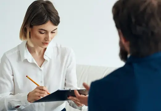Женщина с планшетом записывает слова мужчины на консультации