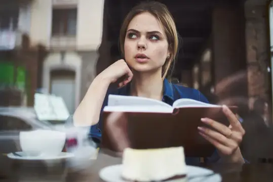 Женщина с книгой отдыхает утром, общается, ведет размеренный образ жизни