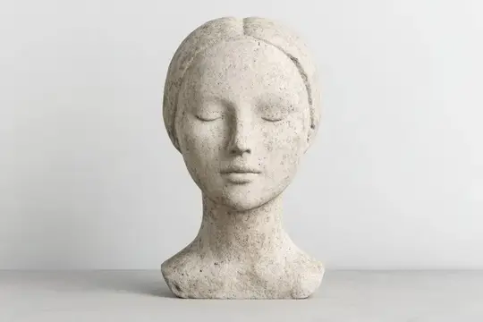 Каменная скульптура головы девушки с закрытыми глазами