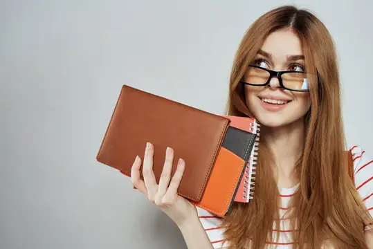 Умная девушка, студентка университета, с блокнотами и в очках