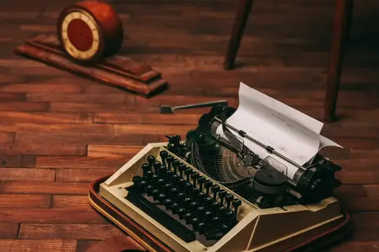 Винтажная печатная машинка с белым листом бумаги на деревянном фоне, ретро-изобретение