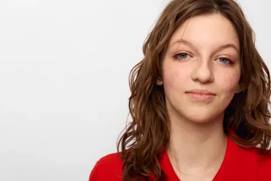 Молодая шатенка с веснушками в красном на белом фоне