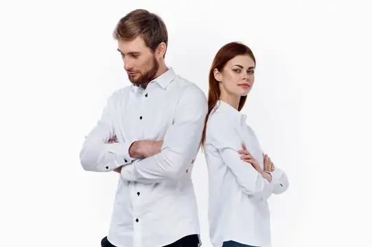 Мужчина и женщина в белых рубашках стоят спина к спине