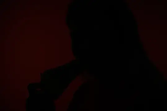 Силуэт девушки на тёмно-красном фоне