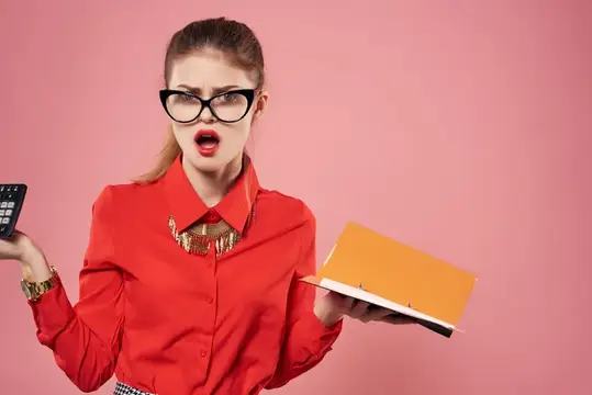 Удивлённая женщина в очках с калькулятором и папкой на розовом фоне