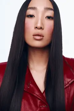 Азиатская девушка с длинными тёмными волосами в красной кожаной куртке