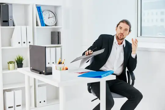 Менеджер работает в офисе с синей папкой для документов
