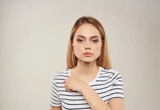 Портрет женщины с blond-волосами на бежевом фоне, крупный план, обрезанный вид