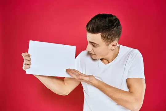 Мужчина держит белый лист бумаги, оставляя место для текста
