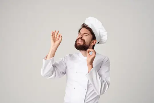 Бородатый мужчина-шеф-повар занимается кулинарией в кулинарной индустрии на светлом фоне