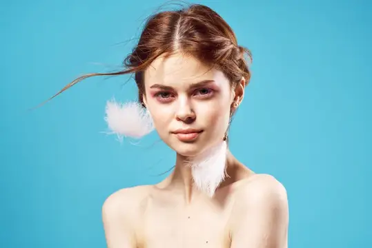 Женщина с обнаженными плечами, пушистые серьги, косметика, мода, крупный план