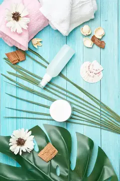SPA-композиция с полотенцами, цветами и косметикой на голубых досках