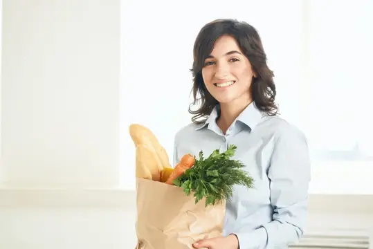 Жизнерадостная женщина с пакетом продуктов, здоровое питание, овощи, домохозяйка