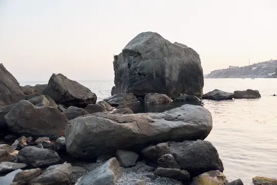 Большие серые камни на берегу моря в сумерках
