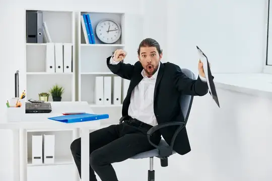 Эмоциональный мужчина в костюме с папкой в светлом офисе