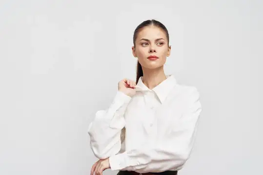 Молодая женщина в белой рубашке на светлом фоне