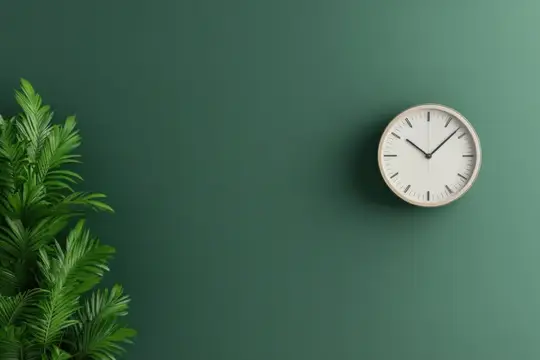 Круглые настенные часы и зелёные ветви пальмы на тёмно-зелёной стене