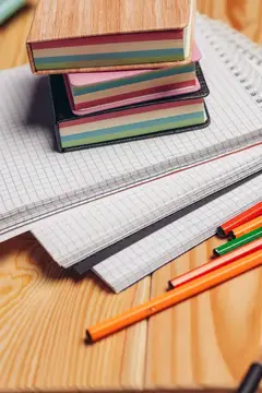 Разноцветные стикеры, блокноты и карандаши на письменном столе крупным планом