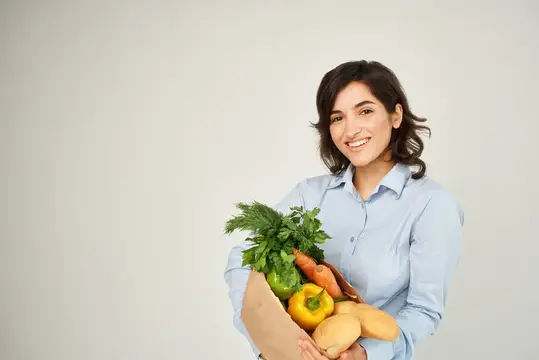 Весёлая женщина с пакетом продуктов, овощей, здоровой еды