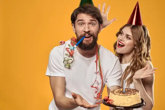Мужчина с дудкой и женщина с тортом веселятся на вечеринке