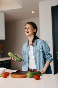 Молодая красивая женщина готовит вкусный и полезный вегетарианский салат на современной кухне