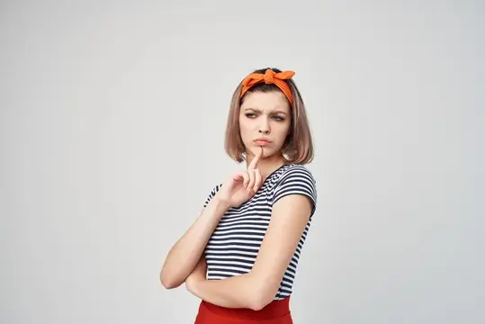 Симпатичная женщина с повязкой на голове в полосатой футболке на светлом фоне