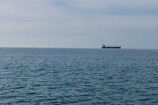Грузовое судно на горизонте в открытом море