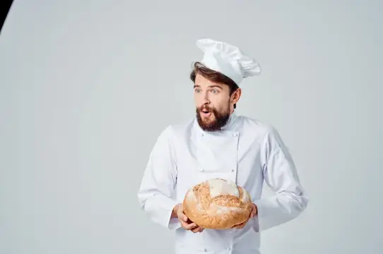 Повар на кухне, работа с хлебобулочными изделиями на светлом фоне