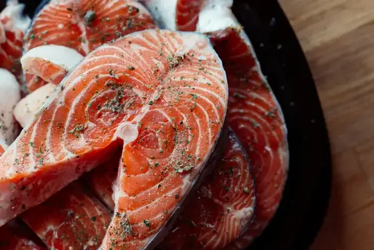 Маринованная красная рыба на тарелке, приготовление морепродуктов, деликатес