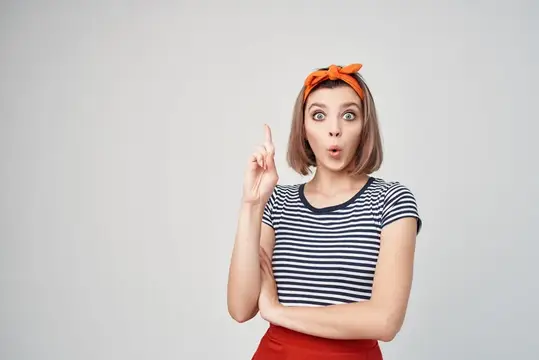 Удивленная девушка с поднятым пальцем и оранжевой повязкой