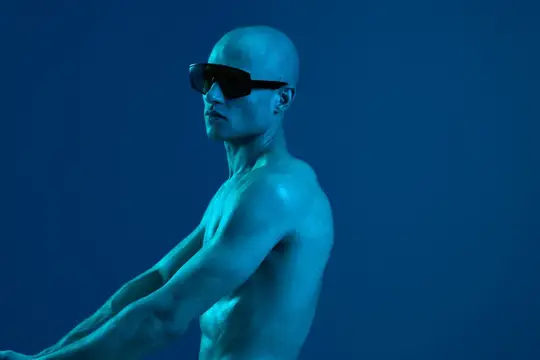 Лысый мужчина в тёмных очках в синем свете