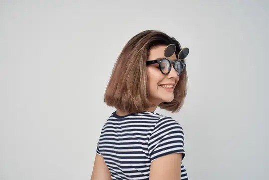 Улыбчивая девушка с каре и солнцезащитными очками на голове