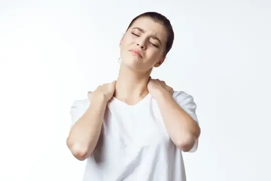 Молодая женщина с закрытыми глазами массирует шею