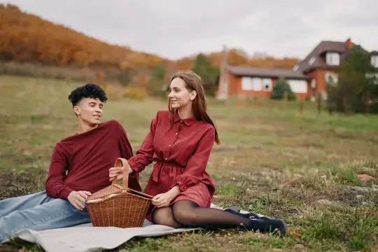 Изображение подчеркивает искренность и доверие через естественное взаимодействие, теплоту и расслабленный стиль в безмятежной осенней обстановке