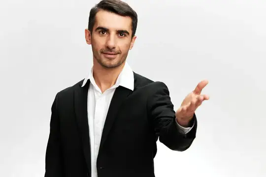 Бизнесмен в черном костюме протягивает руку в приветственном жесте, лидерские навыки, профессиональный белый студийный фон, свободное пространство