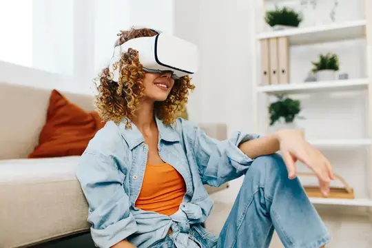 Улыбающаяся женщина наслаждается игрой в виртуальную реальность дома с футуристическими VR-очками и контроллером