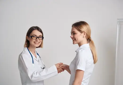 Женщина в футболке пришла на прием к врачу в медицинском халате
