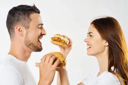 Веселые мужчина и женщина с гамбургерами, фастфуд, закуска, веселье
