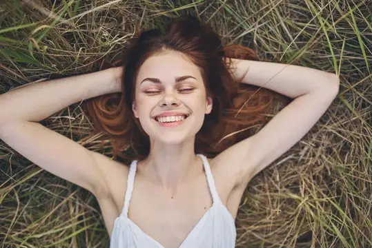 Веселая женщина лежит на соломе в поле, природа, крупный план