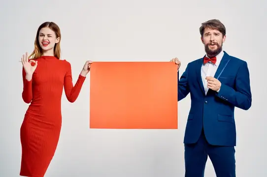 Улыбчивые мужчина и женщина держат оранжевый прямоугольник на белом фоне