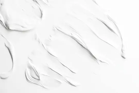 Гладкая текстура белого крема на безупречном фоне, представляющая темы ухода за кожей, красоты и хорошего самочувствия