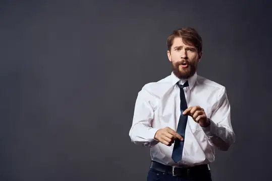 Бизнесмены в белых рубашках, один из них тянет галстук, на тёмном фоне