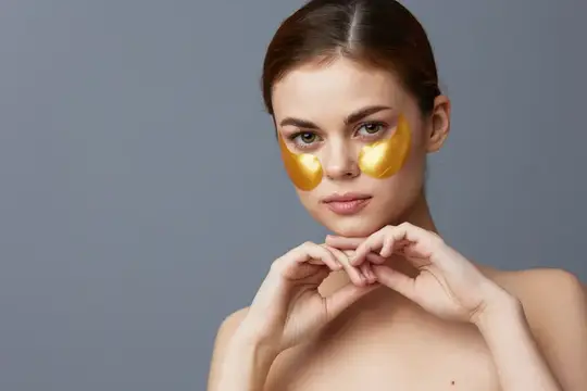 Портрет женщины с золотыми патчами на лице крупным планом