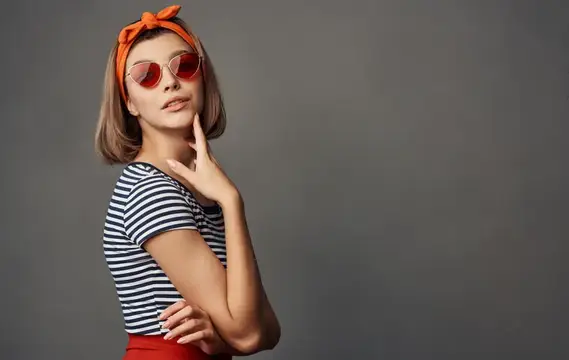 Симпатичная женщина в очках с оранжевой повязкой на голове и красной юбкой, стильная