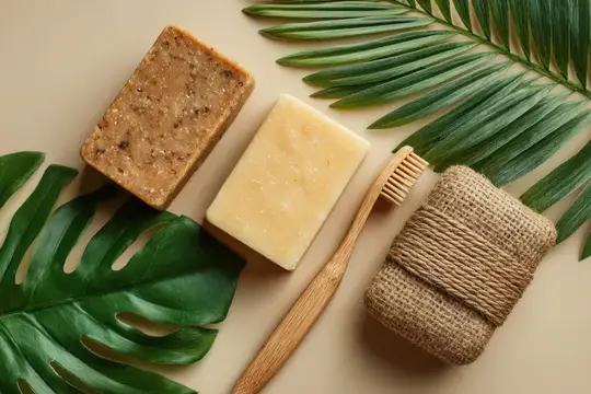 Натуральное мыло, бамбуковая щетка и мочалка на пальмовых листьях
