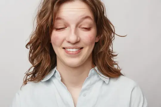Молодая женщина с закрытыми глазами и улыбкой на белом фоне