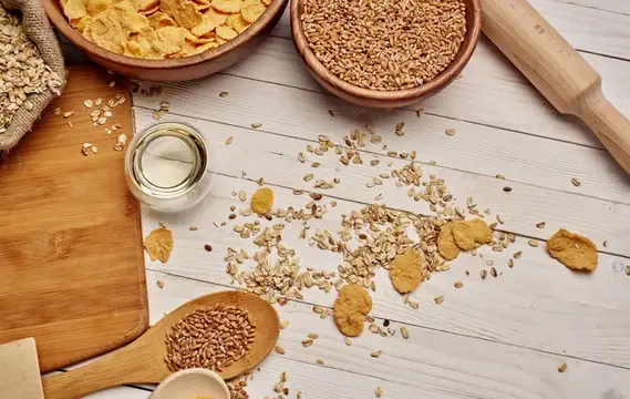 Кукурузные хлопья, зерна и семена на светлом деревянном столе