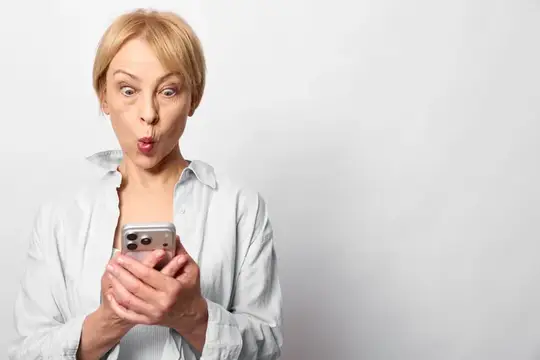 Блондинка с телефоном удивлённо округлила губы на светлом фоне