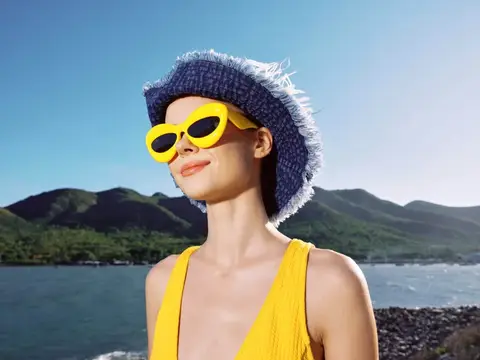 Девушка в жёлтых очках и панаме на фоне гор и моря