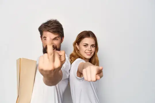 Мужчина и женщина указывают пальцами вперёд на светлом фоне